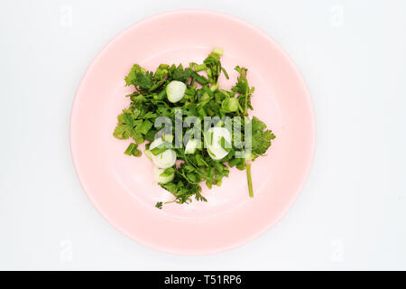 shopped coriander in pink dish on white background. Stock Photo