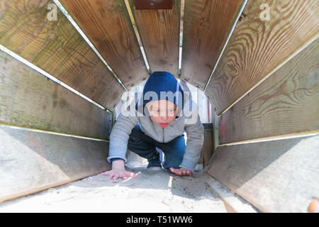 Defect,childcare,medicine and people concept: Blond boy with down syndrome playing in a park. Stock Photo