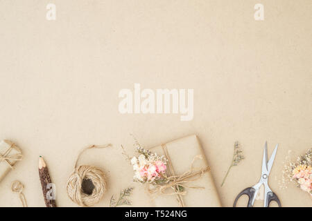 Flat lay top view gift wrapping composition. homemade wrapped  present boxes, decoration and tools on  brown wood background with copy space for your  Stock Photo