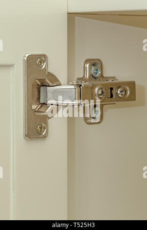 Standard professional hinge for overlay for all kinds of furniture. Hinge  assembled on white doors. Stock Photo