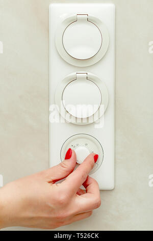Famale hand turn on floor with heating Stock Photo