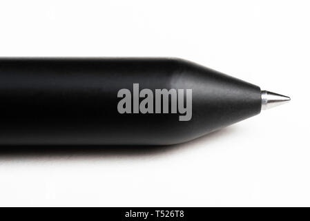 A macro product shot with selective focus of a modern matte finish black clicker barrel ballpoint pen artfully set on a plain white background. Stock Photo