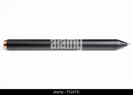 A macro product shot with selective focus of a modern matte finish black clicker barrel ballpoint pen artfully set on a plain white background. Stock Photo