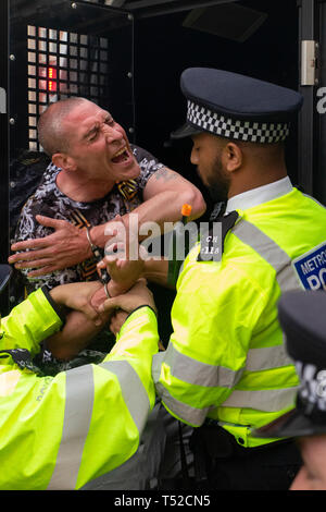 An environmental activist screams out in pain whilst being arrested at the Extinction Rebellion movement occupy London's Oxford Circus