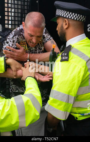 An environmental activist screams out in pain whilst being arrested at the Extinction Rebellion movement occupy London's Oxford Circus