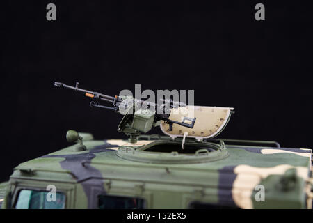 Russian military armored camouflage jeep Tiger. Closeup view. Plastic scale model on dark background. Gun Stock Photo