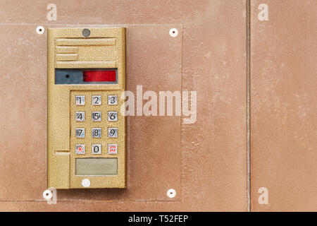 Metal vandal-proof intercom on an old metal door, close-up Stock Photo