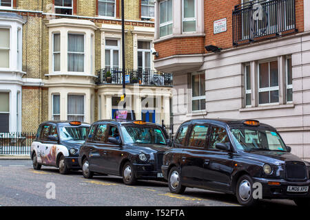 London, Great Britain. April 12, 2019. Kensington street. Cab parking. Cabmen are waiting for customers. London cab is considered the best taxi in the Stock Photo