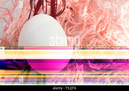 Shooting Easter, one egg on a pink background - damaged file. Abstract texture background noise Glitch camera VHS pixel error. For use in the modern f Stock Photo