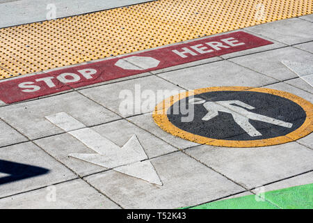 Color road markings for pedestrians at the intersection indicating the direction of movement of pedestrians, indicated by a round sign, and a safe sto Stock Photo