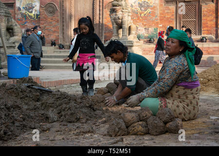 Kathmandu, Nepal - November 26, 2016: Construction labours preparing clay balls used in the reconstruction of a heritage site at Patan durbar square. Stock Photo