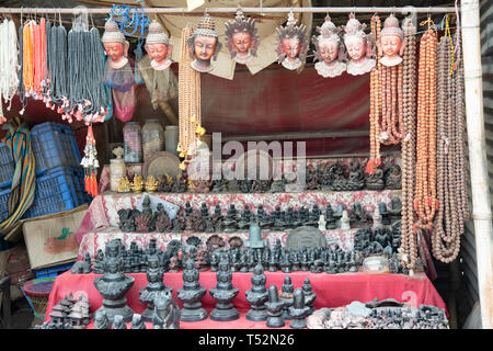 Display of small stone carved idols of Hindu gods and rosaries of rudraksh beads. Stock Photo