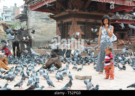 Kathmandu, Nepal - August 27, 2017: Mother with her child stands in the premises of temple courtyard in Hanumandhoka. Stock Photo