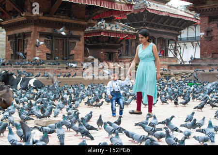 Kathmandu, Nepal - August 27, 2017: Mother with her child stands in the premises of temple courtyard in Hanumandhoka. Stock Photo