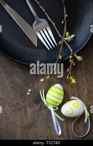 Feastive table setting for holiday Easter dinner decorated with blooming cherry  flowers on rustic table with copy space Stock Photo