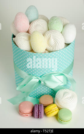 Colorful french macaroons or macarons, meringues and easter eggs in the gift box on white background. Greeting card. Easter holiday concept Stock Photo