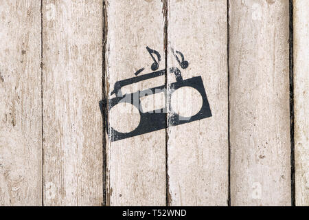 Music playing sign and symbol. Tape recorder with notes on wooden background. Delivery service. Bar, care, night club interior. Vintage, country style Stock Photo