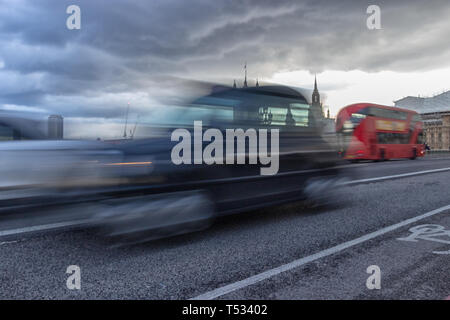 Westminster Bridge, London, England, April 4 2019. A motion blurred iconic London taxi and famous red London bus travelling across the bridge in from Stock Photo