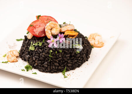 Seafood black Risotto with shrimps colored with Squid ink on white Stock Photo