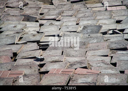 Old worn pavement tiles in the process of dismantling and replacement. Urban economy. Stock Photo