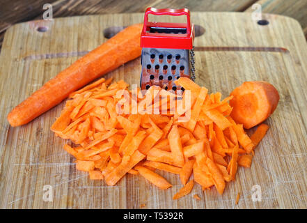 Premium Photo  Shredding grater and shredded carrots on a cutting