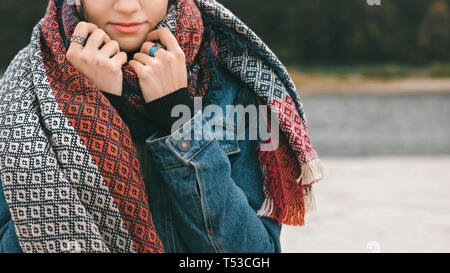 Walk along the river A girl is wrapping in a warm scarf on the riverside Stock Photo