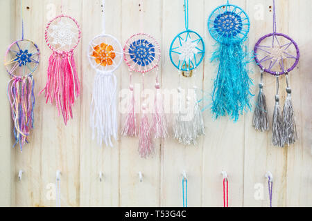 Colorful handmade dream catchers hanging on the white wooden wall Stock Photo