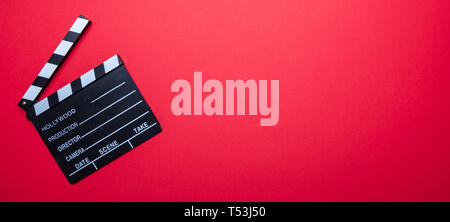 Cinama film concept. Movie clapper board on red color background, banner, copy space Stock Photo