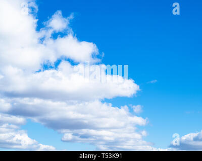 front of white clouds in blue sky in sunny spring day Stock Photo