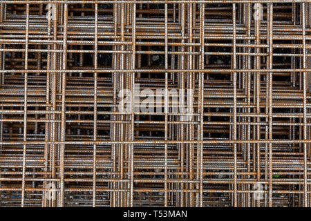 Rusty square reinforcement mesh for concrete at construction site. Iron mesh panels background. Stock Photo