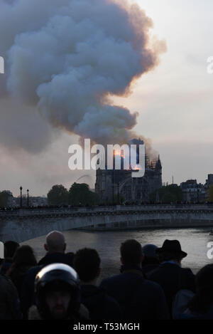 *** FRANCE OUT / STRICTLY NO SALES TO FRENCH MEDIA *** April 15, 2019 - Paris, France: Parisians on a bridge watch as a large fire burns in Notre Dame cathedral of Paris. Stock Photo