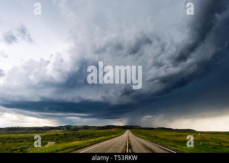 Straight road leading to dark storm clouds near Joliet, Montana, USA Stock Photo
