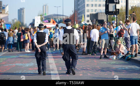 London, UK.20th  April 2019. Police officers walk towards the Extinction Rebellion protesters on Waterloo Bridge on Day 6 of climate change protests i Stock Photo
