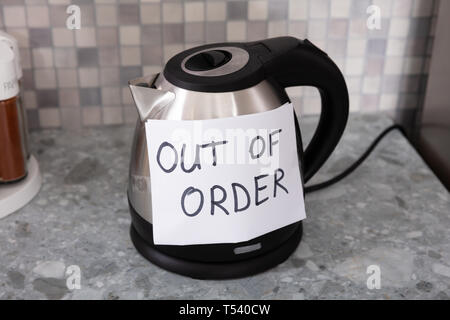 Written Text Out Of Order Message On Paper Over The Stuck Electrical Kettle Stock Photo
