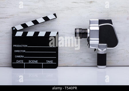 Close-up Of An Movie Camera And Clapper Board On Desk Stock Photo