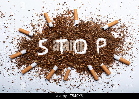 An Elevated View Of Frame Made With Broken Cigarettes Around Stop Word Written On Tobacco Stock Photo