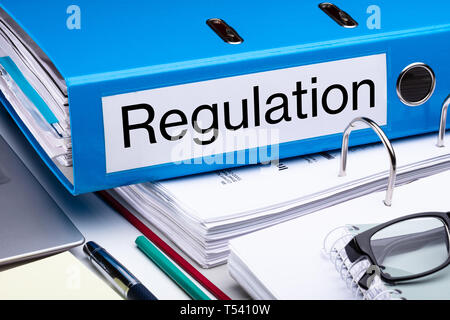 Blue Regulation Folder And Files On Business Desk Stock Photo