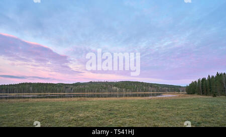 Purple Sunset over a field and hill Stock Photo