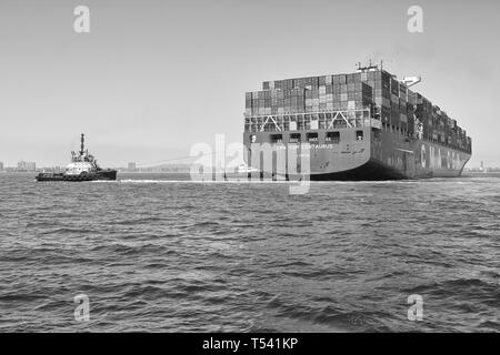 Black And White Photo Of Container Ship, CMA CGM CENTAURUS, Being Turned Through 180 Degrees By 2 Tugs Before Docking In Long Beach, California, USA. Stock Photo