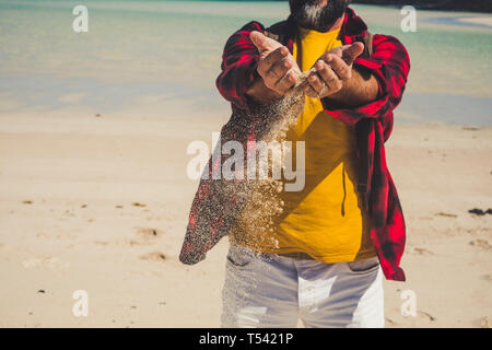 Close u view of unrecognizable caucasian tourist man playing with the sand at the beach durint tropical vacation - adult people enjoy the nature in su Stock Photo