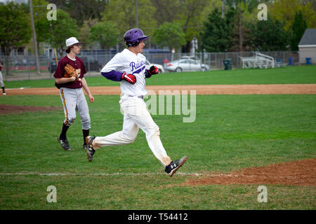 Teenage baseball player running for 1st base at the Cretin-Derham Hall school home Field. St Paul Minnesota MN USA Stock Photo