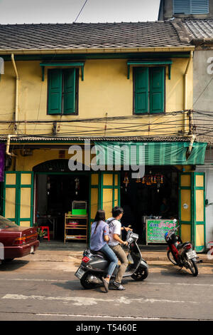 Thailand, Bangkok, Thanon Fuang Nakhon, couple on scooter parking outside, traditional shop house Stock Photo