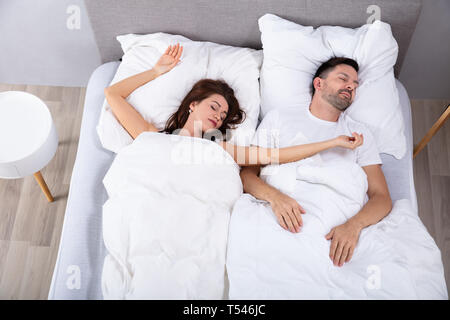 Elevated View Of Married Young Couple Napping On Bed Stock Photo