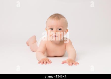 Cute little baby boy in diapers crawling on white background,bright picture of crawling curious baby over white backgroubd Stock Photo