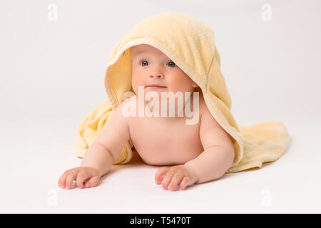 toddler boy with yellow towel on head on white background, Portrait of cute Caucasian newborn baby. The child is wrapped in a yellow soft towel after Stock Photo