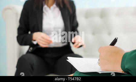 psychotherapeutic session. blurred businesswoman talks with his psychologist taking notes Stock Photo
