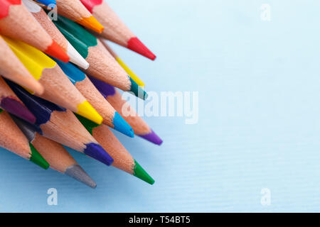 A group of bright wooden pencils lying on a blue background. Drawing supplies: assorted color pencils. copyspace Stock Photo