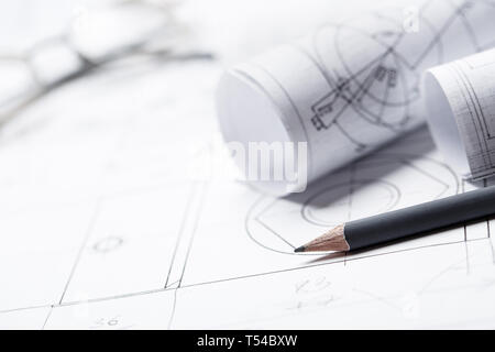 Rolls of drawings with eyeglasses in the background. The set of elements reflecting the concept of engineering and design. selective focus Stock Photo