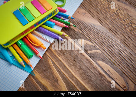 School supplies on the left side of the background. Bright pencils on a notebook. copyspace Stock Photo