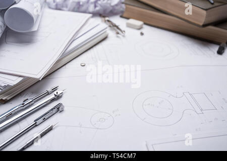 Architectural prints and print rolls and a drawing instruments on the worktable. architectural background with rolls of technical drawings and bluepri Stock Photo